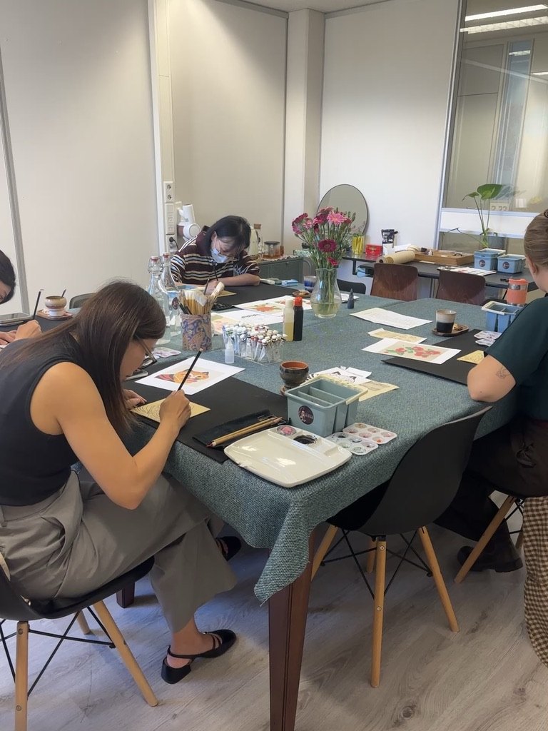Students painting Minhwa together around the studio table