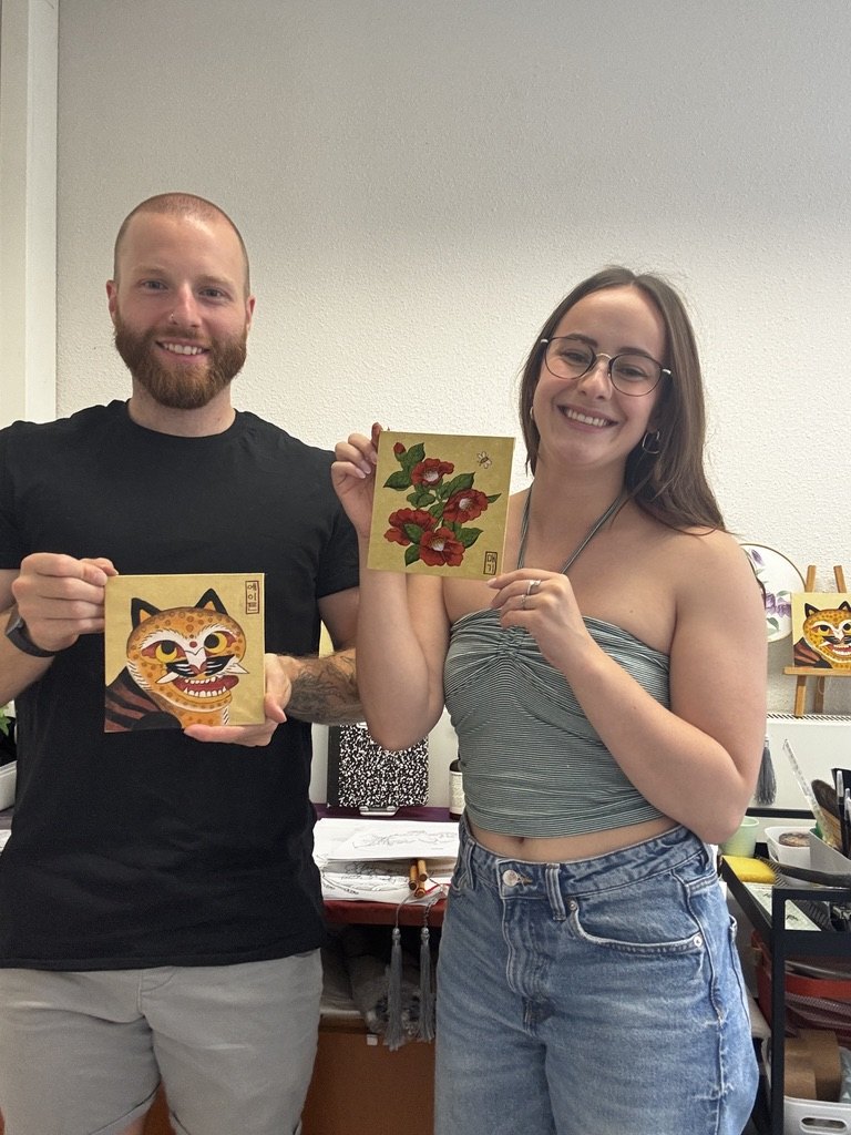 Student holding a finished Minhwa painting