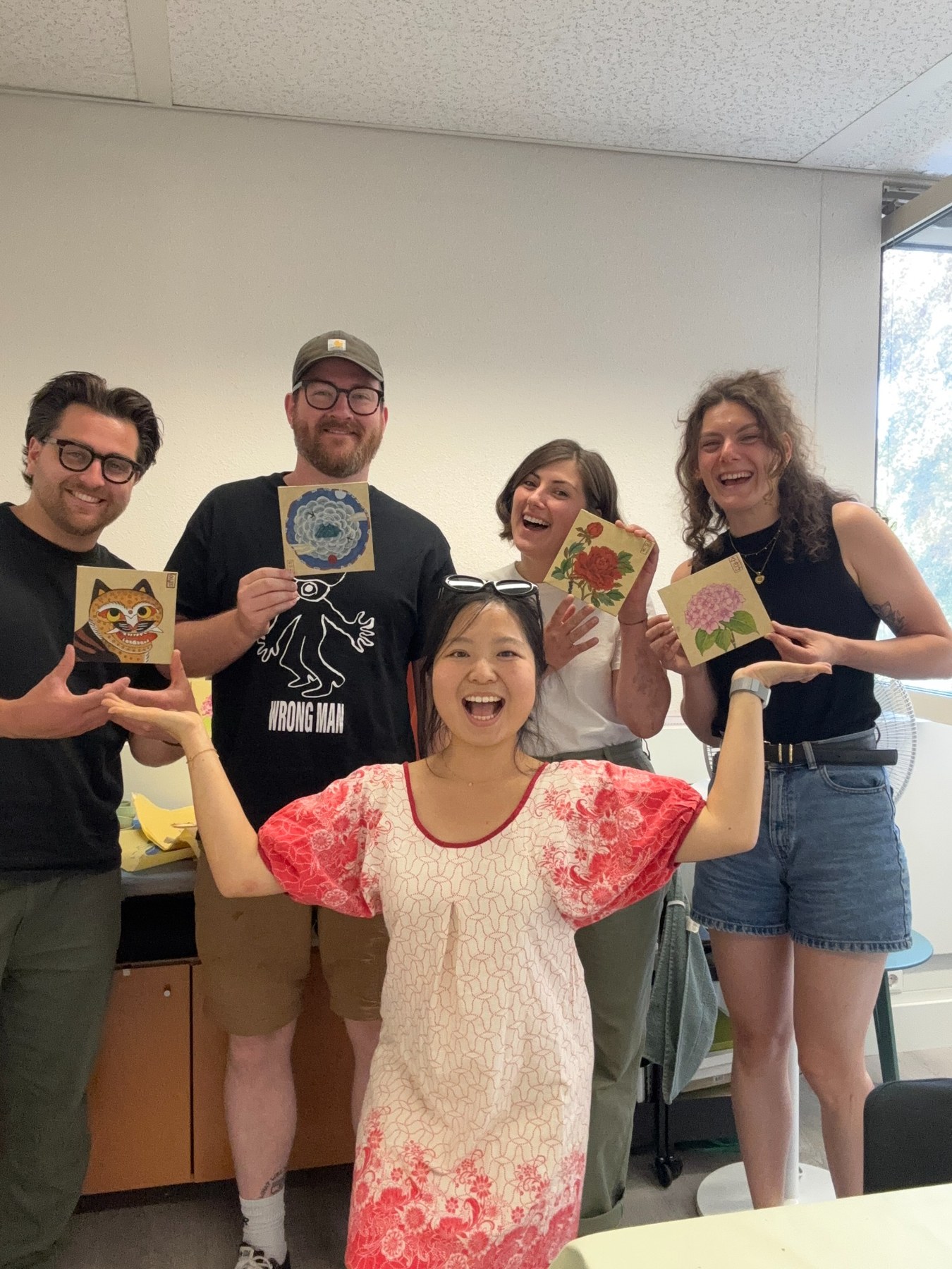 Group of students celebrating with their finished Minhwa paintings